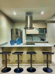 马萨特兰The Altomare - Seaview.的厨房配有带四把吧台凳的吧台