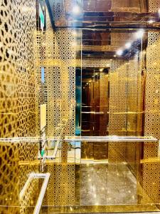 a bathroom with a mirror and gold tiles at 2-х комнатная квартира в ЖК класса Luxe, Тосмур in Alanya