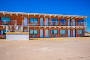 a red brick building with a balcony on top of it at OYO Crossroads Inn in Osborne