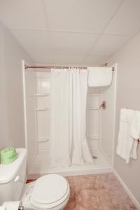a white bathroom with a toilet and a shower at OYO Crossroads Inn in Osborne