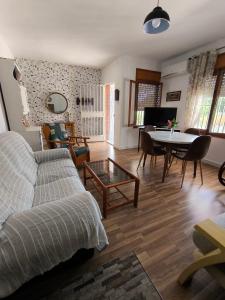 a living room with a couch and a table with chairs at El Jazmín in San Vicente del Raspeig