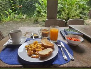 a plate of food on a table with toast and orange juice at In Situ Hotel in Cali