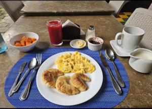 a plate of eggs and croissants on a table at In Situ Hotel in Cali