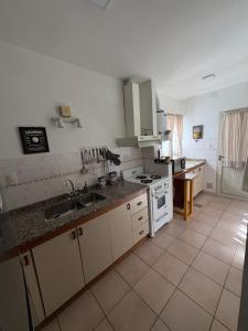 una cocina con fregadero y estufa en Casa Zeballos, en Sunchales 2 fotos más