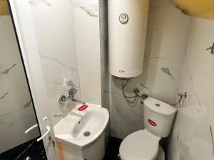 a white bathroom with a toilet and a sink at Мансарда in Nesebar