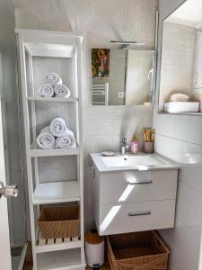 a bathroom with a sink and a mirror and towels at Bel appartement à Deauville - vue mer et port in Deauville