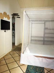 une chambre avec un lit dans un cadre de lit suspendu dans l'établissement Havana, à Diego Suarez