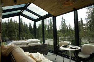 a glass room with a bed and a table at Wilding Hotels Fairbanks in Fairbanks