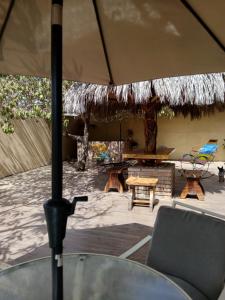 Un patio con una sombrilla y una mesa y sillas. en Casa Laura, en El Venadillo