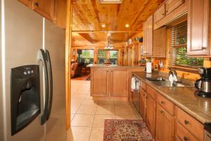 a kitchen with wooden cabinets and a stainless steel refrigerator at Glimpse of Bearadise in Gatlinburg +53 photos