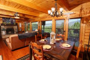 a dining room and living room with a table in a cabin at Glimpse of Bearadise in Gatlinburg
