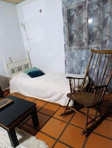 a bedroom with a rocking chair and a bed at Casa costanera oeste in Posadas