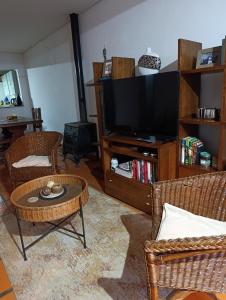 a living room with a tv and chairs and a table at Casa costanera oeste in Posadas
