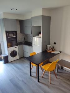 a kitchen with a table and chairs in a room at Cabañita areas gordas in A Lanzada