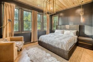 a bedroom with a large bed and windows at Morgan Trail - Stunning Mountain Masterpiece in Epworth