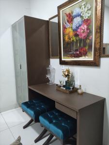 a table with blue padded stools and a painting of flowers at Casa Fernandes in Rio Verde