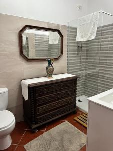 a bathroom with a toilet and a sink and a mirror at Casa Vintage Guest House in Peniche