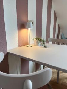 a table with a lamp and a white chair at K2-Project - Hotspot - am Puls der Stadt in Chemnitz +9 photos