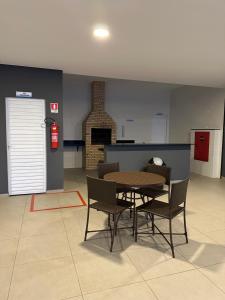 ein Esszimmer mit Tisch und Stühlen und einem Kamin in der Unterkunft Apartamento 403 no Calhau in São Luís