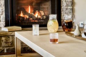 a living room with a fireplace and a table with jars of honey at The Howell House - Picturesque Countryside Retreat in Starkville