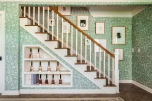 a staircase with wine bottles on a green wall at The Howell House - Picturesque Countryside Retreat in Starkville +61 photos