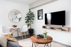 a living room with a flat screen tv on a wall at <THE MYLO> Walkable | Rooftop | Skyline | Dreamy in Atlanta