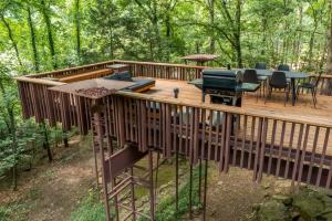 eine Terrasse im Wald mit Grill und Klavier in der Unterkunft Stoneflower Cottage in Heber Springs