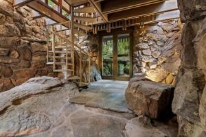 ein Steinhaus mit einer Treppe und einer Steinmauer in der Unterkunft Stoneflower Cottage in Heber Springs