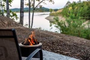 Una fogata sentada en un banco junto a un río en Bearfoot Bungalow - Lakefront Paradise, en Sevierville