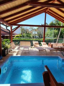 a swimming pool with chairs and a table at Apartmani Vesna Tuheljske toplice in Tuheljske Toplice
