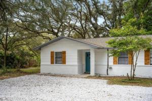a small white house with a blue door at The PanAm fire pit bbq kid & dog friendly in Pensacola