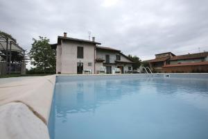 an empty swimming pool in front of a house at Ospitidelpero in Piozzo
