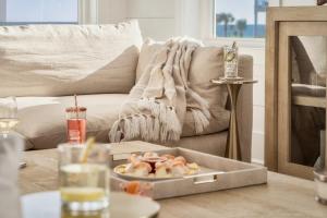 a living room with a table with a plate of food at Whitecap - Beachfront Gem with Pool & Elevator in Orange Beach +48 photos