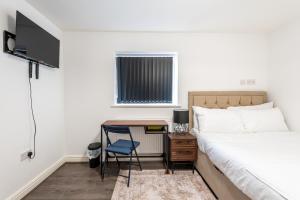a bedroom with a bed and a desk with a chair at Contractor Stay and Holiday Let - Sleeps 3 in Coventry