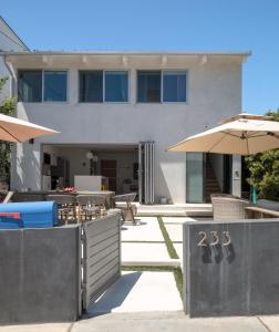 マンハッタン・ビーチにあるYour Coastal Getaway in Manhattan Beach Awaitsの傘とテーブルと椅子のある建物 +42枚の写真