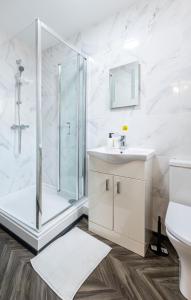 a white bathroom with a shower and a sink at Comfy Contractor and Holiday Studio - Sleeps 2 in Coventry