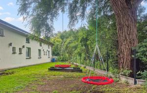 a yard with three red tricycles sitting next to a tree at 1 Bedroom Amazing Home In Sarbinowo in Sarbinowo