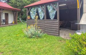 a cabin with a red roof in a yard at 1 Bedroom Amazing Home In Sarbinowo in Sarbinowo +11 photos