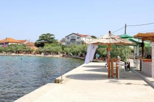 a resort with a pool and an umbrella and a beach at Seaside holiday house Bibinje, Zadar - 5854 in Bibinje +8 photos