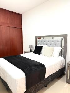 a bedroom with a large bed with black and white pillows at Encanto de Playa Sur By GEstores in Mazatlán