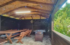 an outdoor patio with a wooden table and benches at Beautiful Home In Sarbinowo With Wifi in Sarbinowo +14 photos