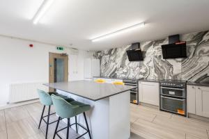 a kitchen with a counter and two stools at Sleek Luxe Room - Contractor and Holiday Stay in Coventry