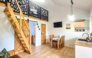 a kitchen with a table and a staircase in a room at Beautiful Home In Sarbinowo With Wifi in Sarbinowo
