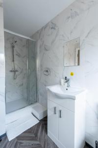 a white bathroom with a shower and a sink at Sleek Luxe Room - Contractor and Holiday Stay in Coventry
