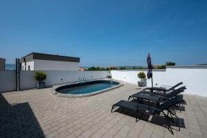 a patio with chairs and a pool on a building at Family friendly house with a swimming pool Maslenica, Novigrad - 23719 in Jasenice