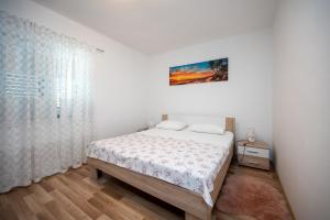 a white bedroom with a bed and a window at Family friendly house with a swimming pool Maslenica, Novigrad - 23719 in Jasenice