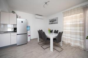 a kitchen and dining room with a white table and chairs at Family friendly house with a swimming pool Maslenica, Novigrad - 23719 in Jasenice +15 photos