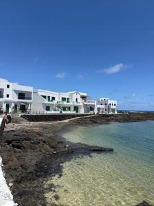 a group of white houses on a beach with the water at La Playa in Órzola