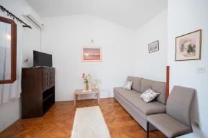 a living room with a couch and a tv at Apartments and rooms with parking space Sukosan, Zadar - 24693 in Sukošan