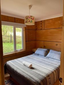 a bedroom with a large bed with a window at Casa loft con opción de tina temperada in Puerto Varas